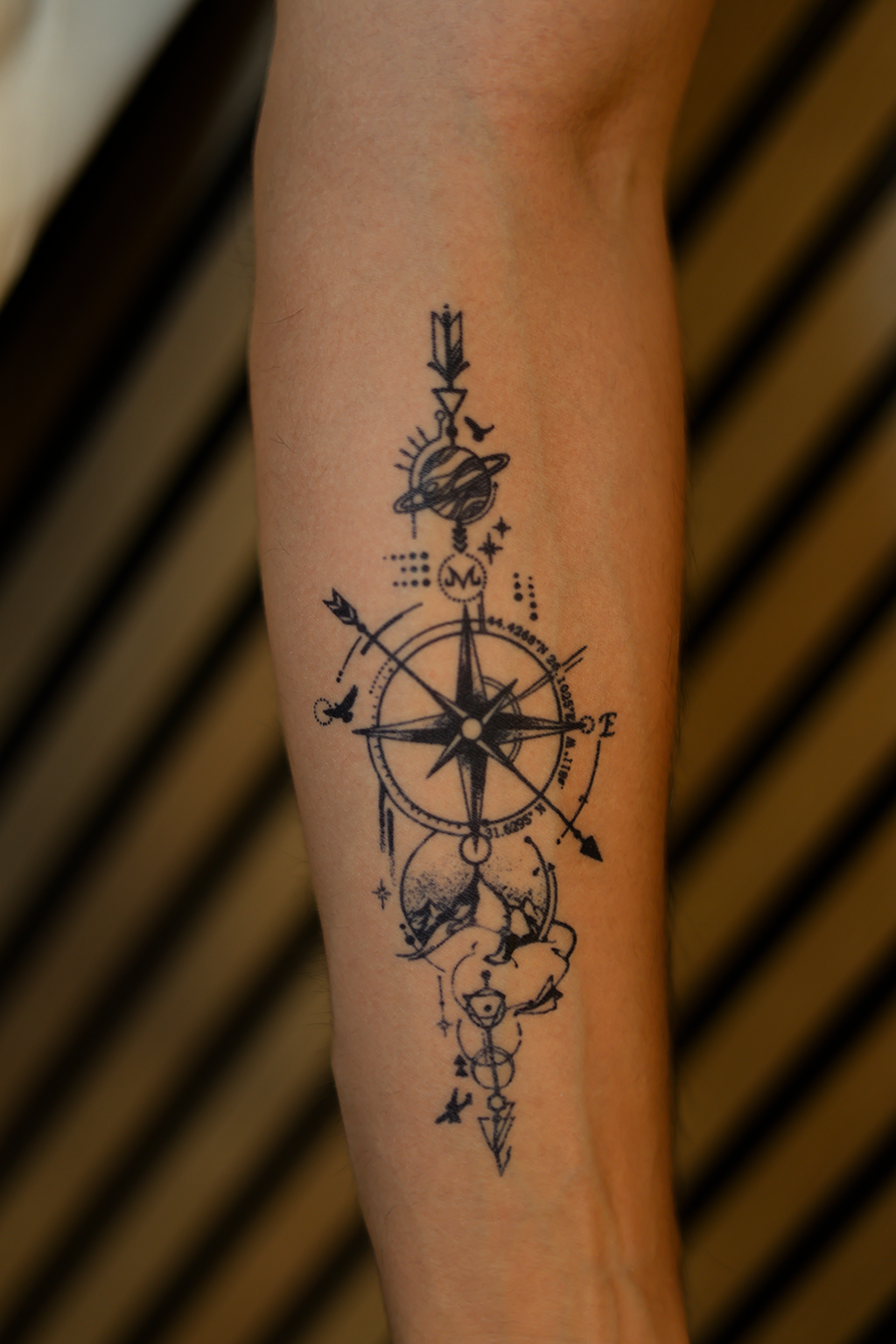 Model fin de tatuaj cu contururi negre, reprezentând o ilustrație cu busolă